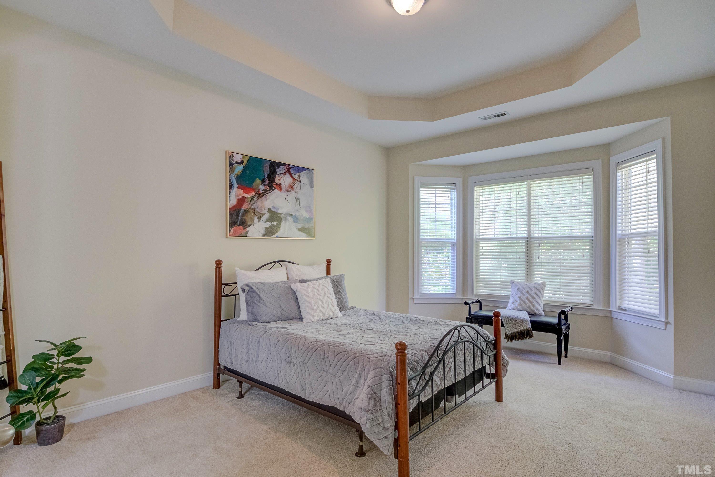 1016 Chapanoke Road Raleigh, NC 27603 - Photo 23 of 49 a bedroom with a bed a large window and potted plant on the dresser