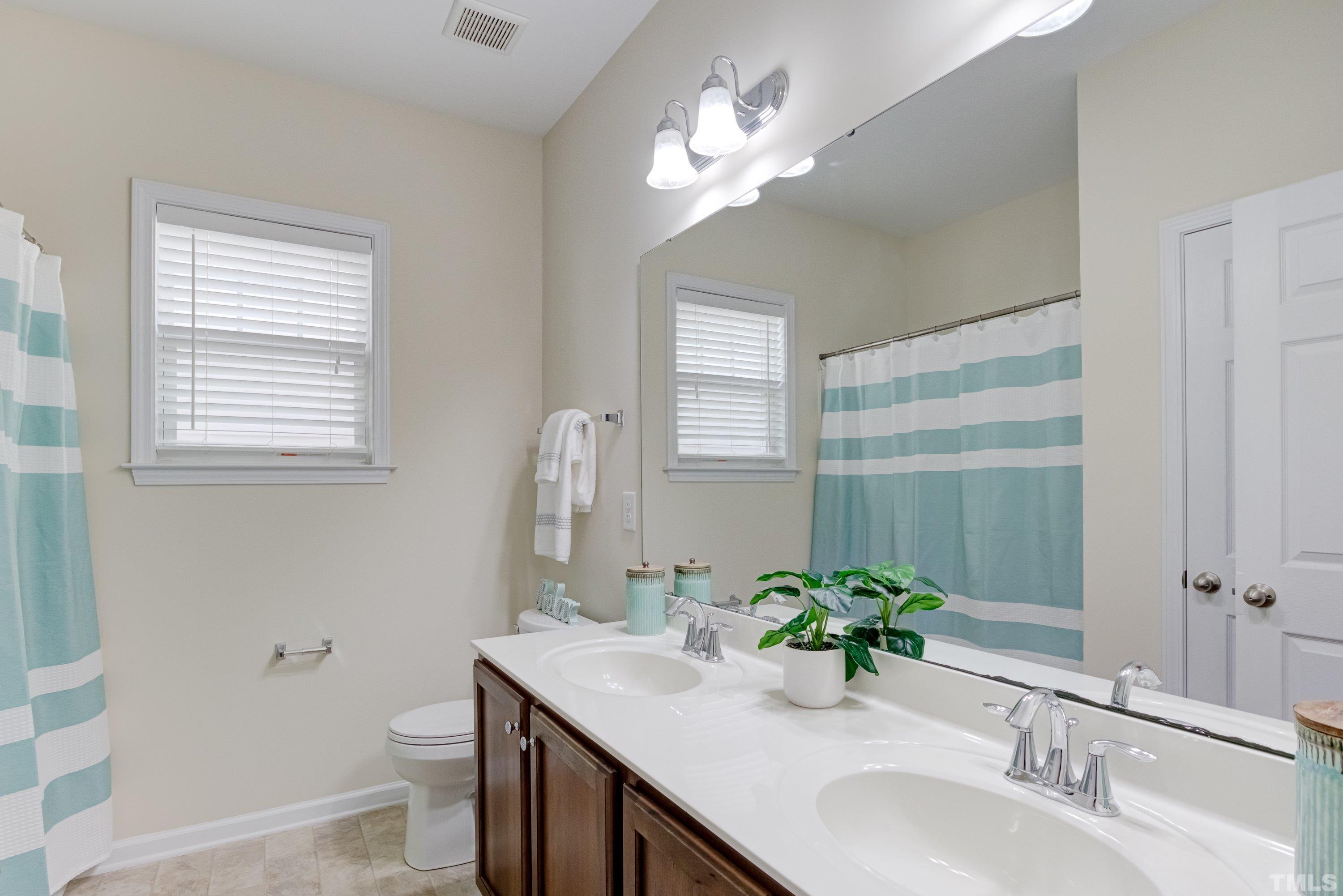 1016 Chapanoke Road Raleigh, NC 27603 - Photo 33 of 49 a bathroom with a granite countertop sink a toilet and a mirror