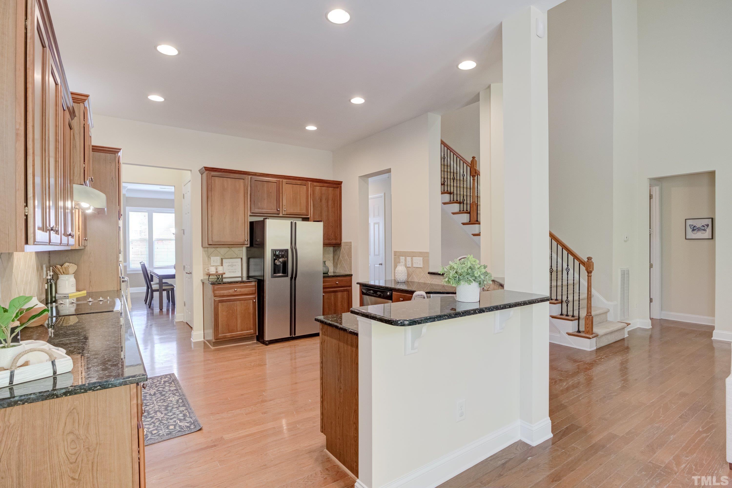 1016 Chapanoke Road Raleigh, NC 27603 - Photo 8 of 49 a kitchen with stainless steel appliances kitchen island granite countertop a refrigerator and a sink