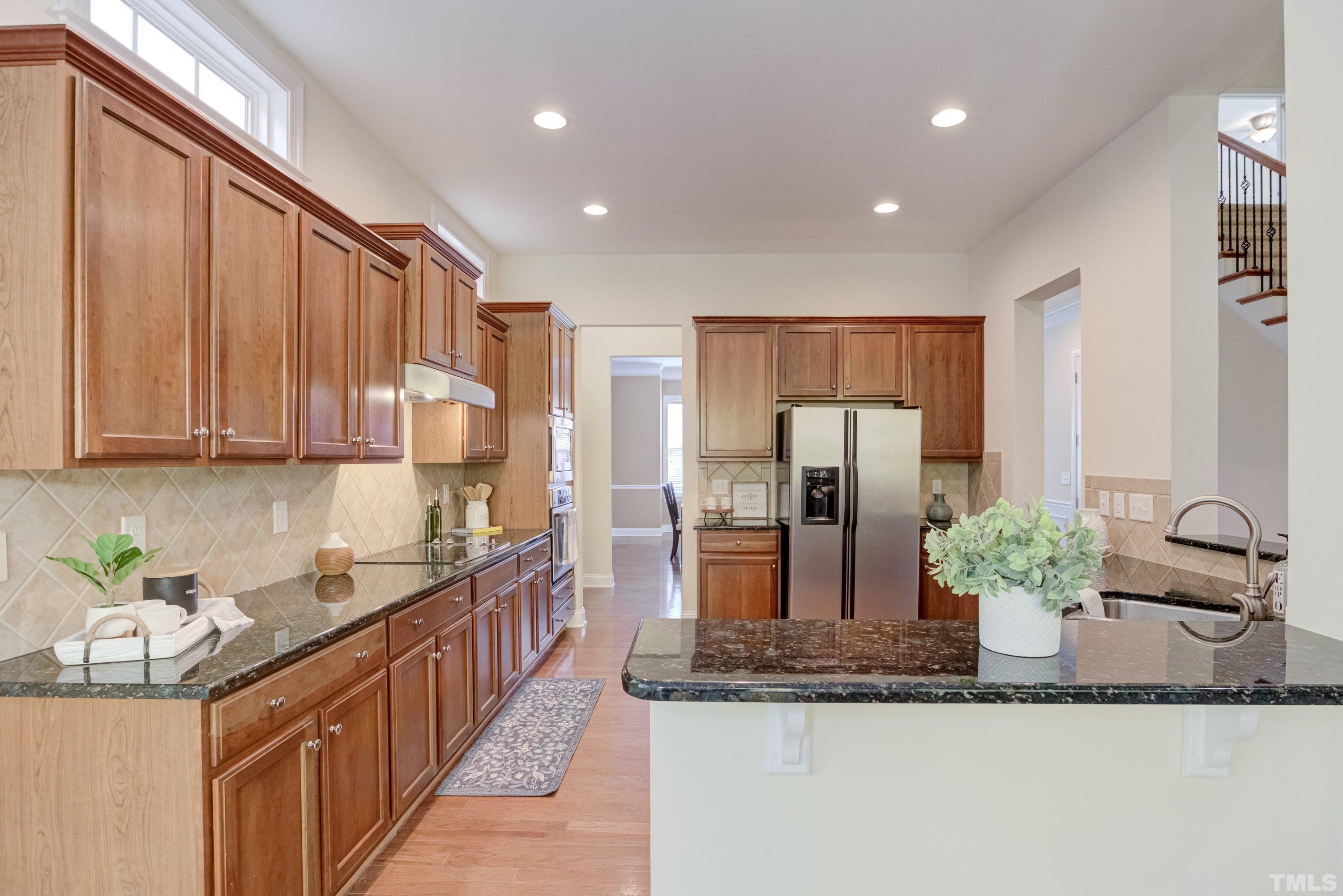1016 Chapanoke Road Raleigh, NC 27603 - Photo 9 of 49 a kitchen with stainless steel appliances granite countertop a sink and a refrigerator
