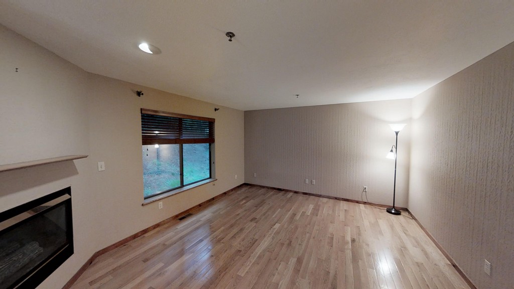 33 Ridgewood Drive, Unit 33 Atkinson, NH 03811 - Photo 5 of 19 a view of empty room with wooden floor and fireplace