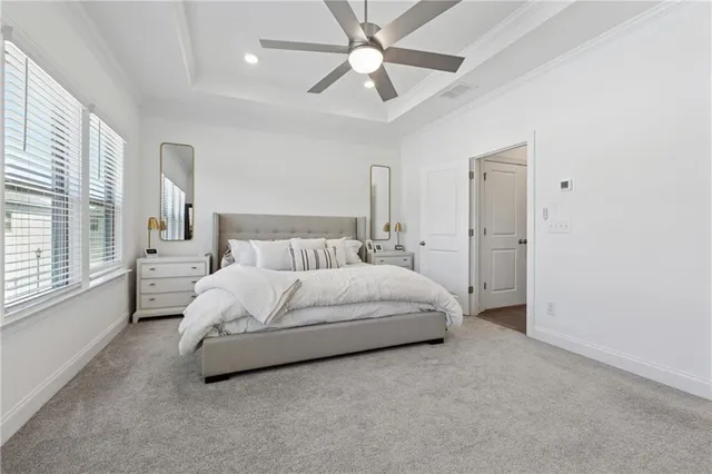 a large bed sitting in a bedroom next to a window and a chandelier