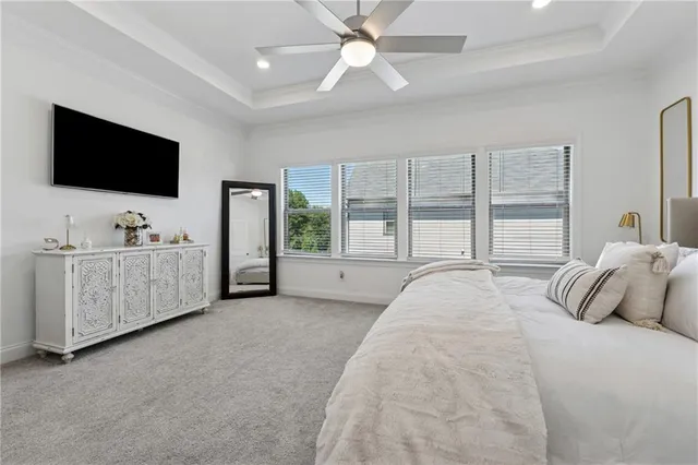 a spacious bedroom with a large bed and a flat screen tv