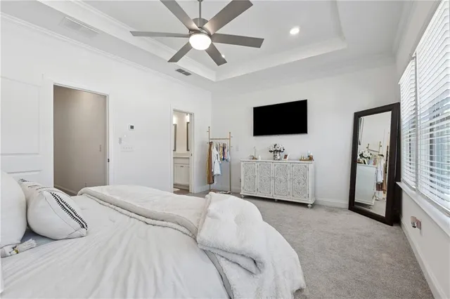 a spacious bedroom with a bed and a flat screen tv