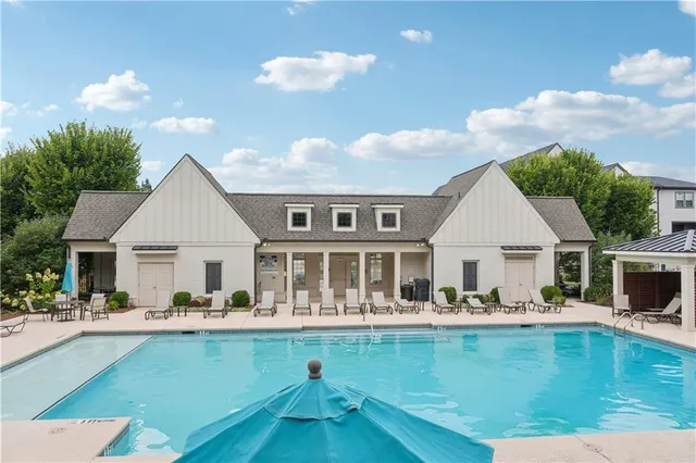 a front view of a house with swimming pool and outdoor seating
