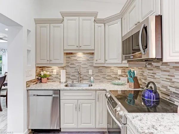 a kitchen with stainless steel appliances granite countertop a sink stove and cabinets