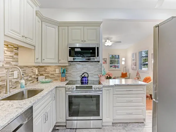 a kitchen with stainless steel appliances granite countertop a sink stove a microwave and cabinets