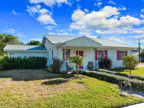 a front view of a house with a yard and lake view