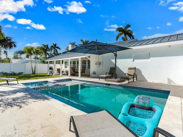 a view of a swimming pool with a patio and a yard