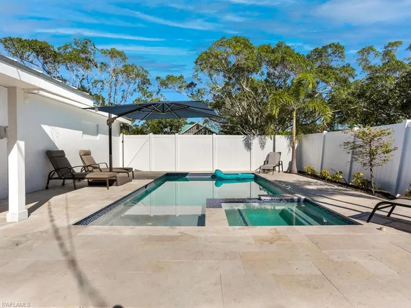 a view of a swimming pool with a patio and a yard