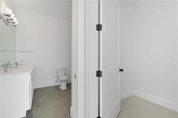a bathroom with a granite countertop toilet and a sink