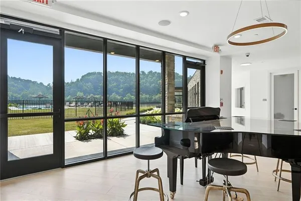 a living room with furniture wooden floor kitchen view and a chandelier