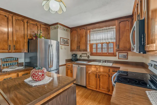 a kitchen with stainless steel appliances granite countertop a sink stove and refrigerator
