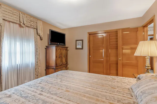 a bedroom with a bed and a flat screen tv