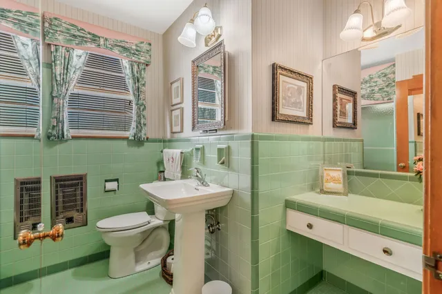 a bathroom with a toilet sink and mirror