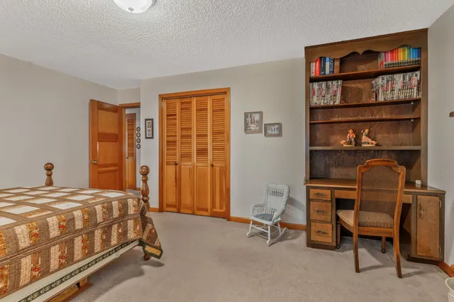 a bedroom with a bed a table and a bookshelf