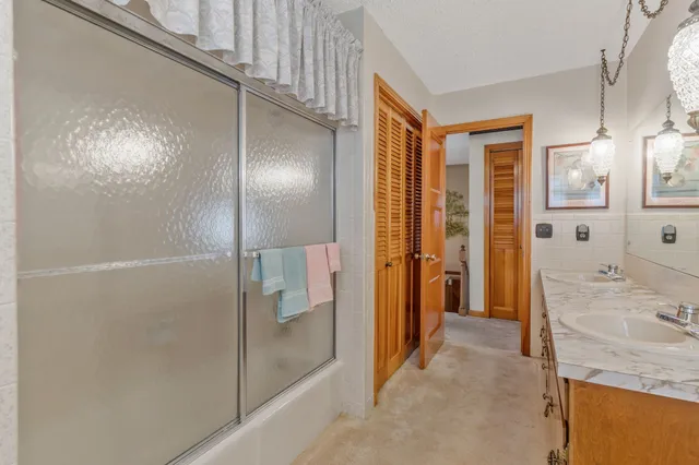 a bathroom with a granite countertop sink mirror and shower