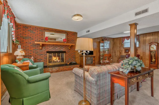 a living room with furniture a fireplace and a large window