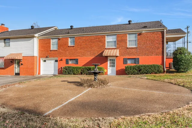 a front view of a house with a yard and a garage