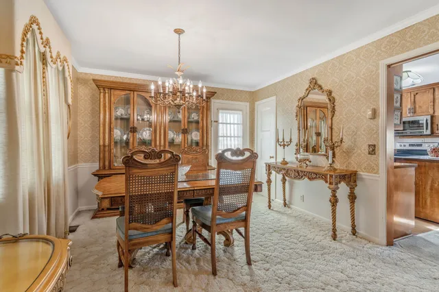 a view of a dining room with furniture and chandelier