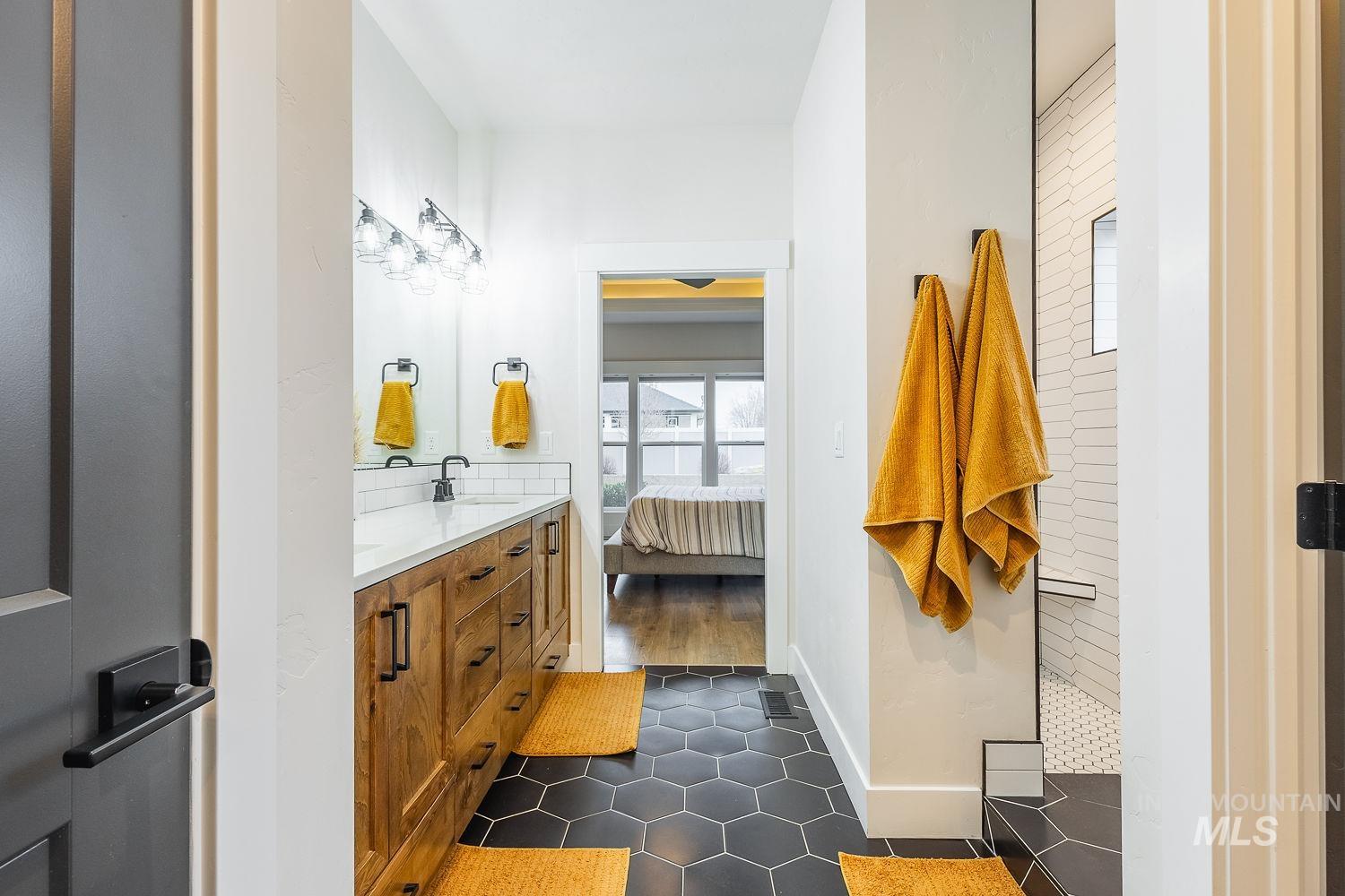 2206 Seafarer Court Middleton, ID 83644 - Photo 16 of 37 Ensuite bathroom with double vanity, walk in shower, and dark tile patterned flooring