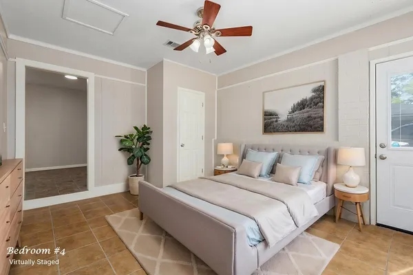 a bedroom with a large bed and a potted plant