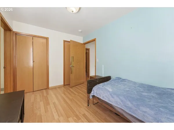 a bedroom with a bed and wooden floor