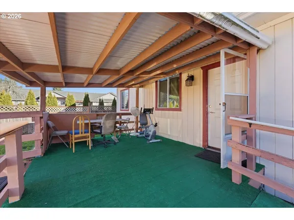 a view of a backyard with table and chairs and a barbeque