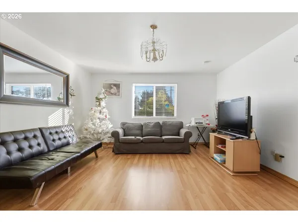 a living room with furniture flat screen tv and wooden floor