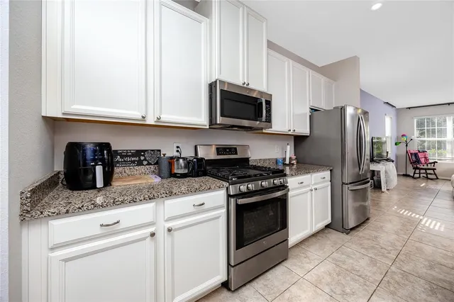 a kitchen with stainless steel appliances granite countertop a stove a refrigerator and a sink