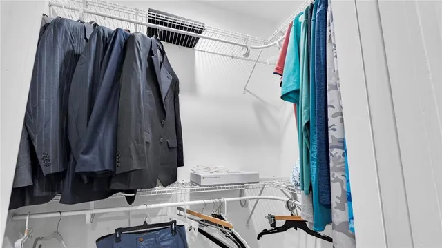 a view of a hallway with wooden floor and a bathroom