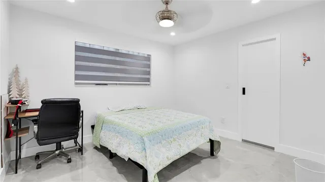 a bedroom with a bed and a painting on the wall