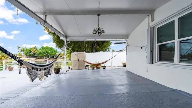 a living room with patio furniture and a potted plant