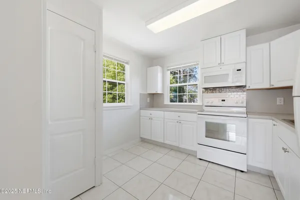 an aerial view of residential houses with outdoor space and trees