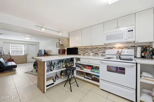 a kitchen with white cabinets and white appliances
