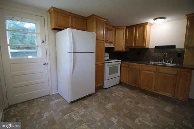 a kitchen with a refrigerator sink and cabinets