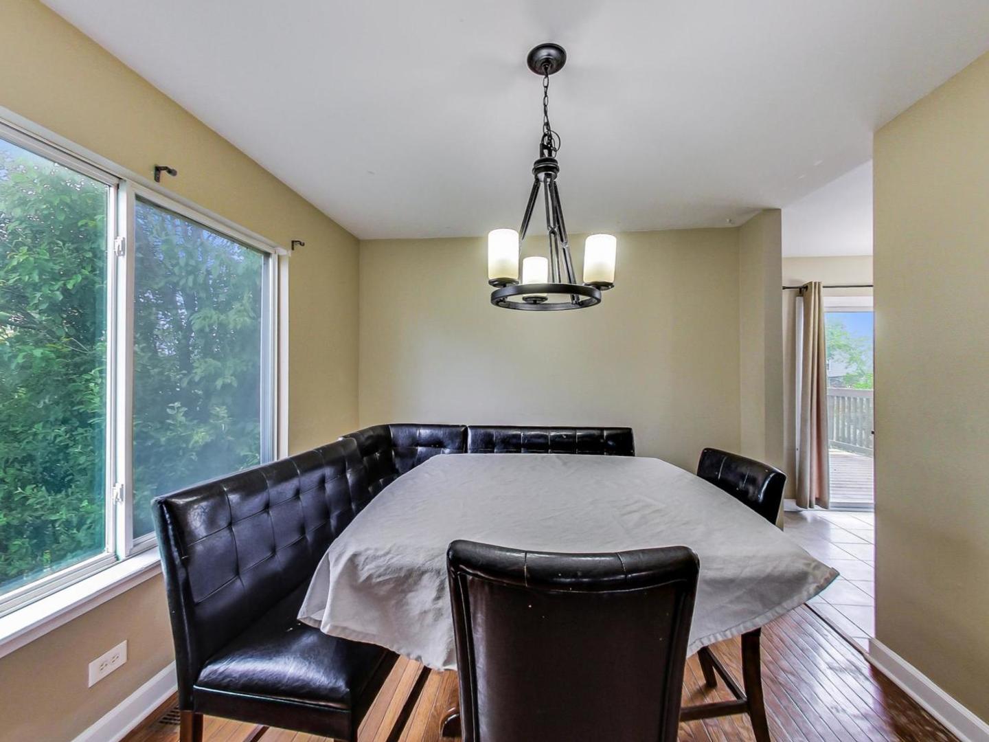 2385 North Periwinkle Way Round Lake Beach, IL 60073 - Photo 11 of 51 a view of a dining room with furniture wooden floor and chandelier