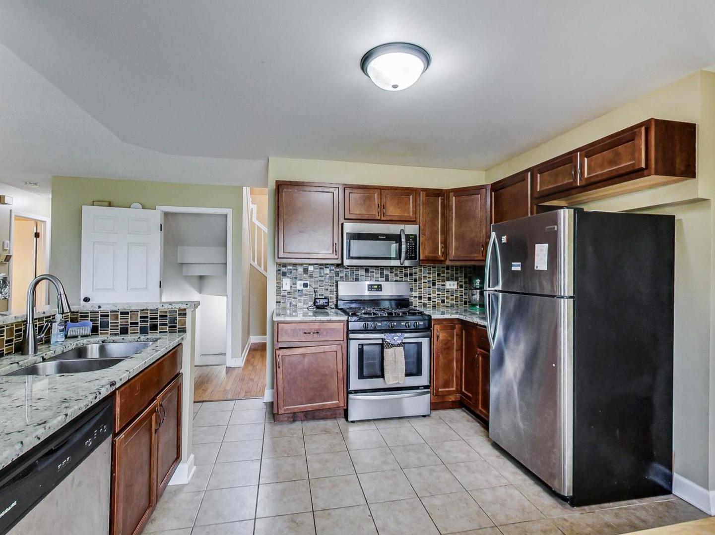 2385 North Periwinkle Way Round Lake Beach, IL 60073 - Photo 12 of 51 a kitchen with stainless steel appliances granite countertop a refrigerator stove and oven
