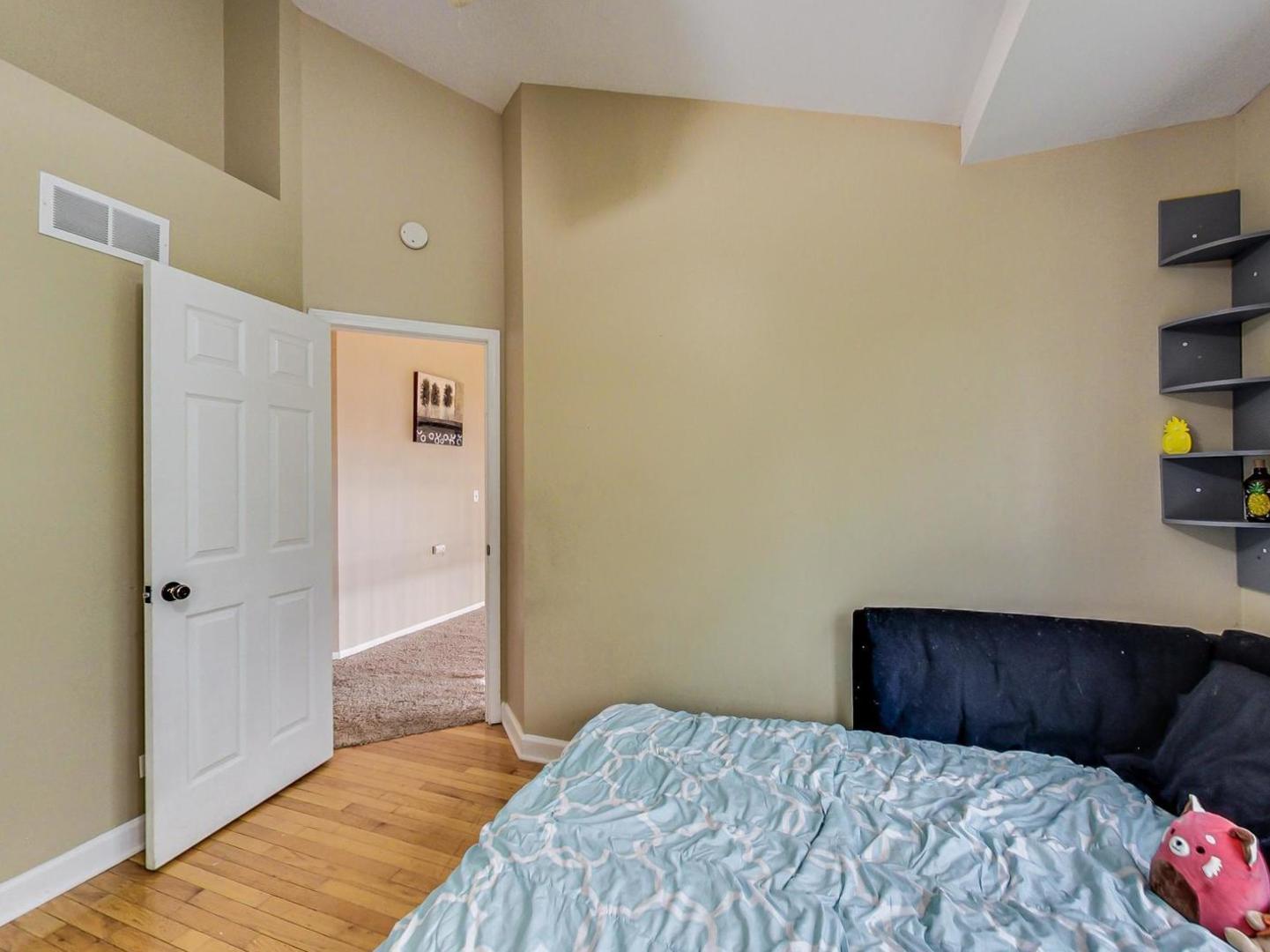 2385 North Periwinkle Way Round Lake Beach, IL 60073 - Photo 33 of 51 a bedroom with a bed and a book shelf