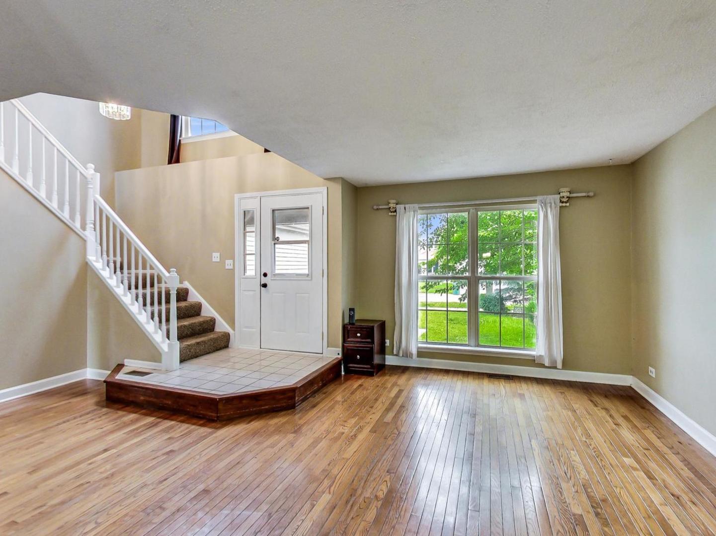 2385 North Periwinkle Way Round Lake Beach, IL 60073 - Photo 7 of 51 a view of an empty room with wooden floor and a window