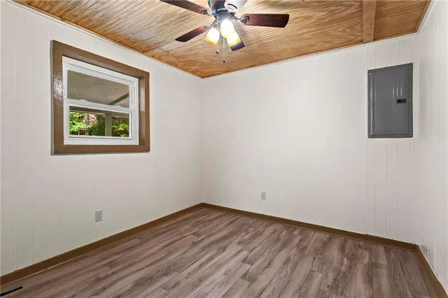 an empty room with a ceiling fan and wooden floor