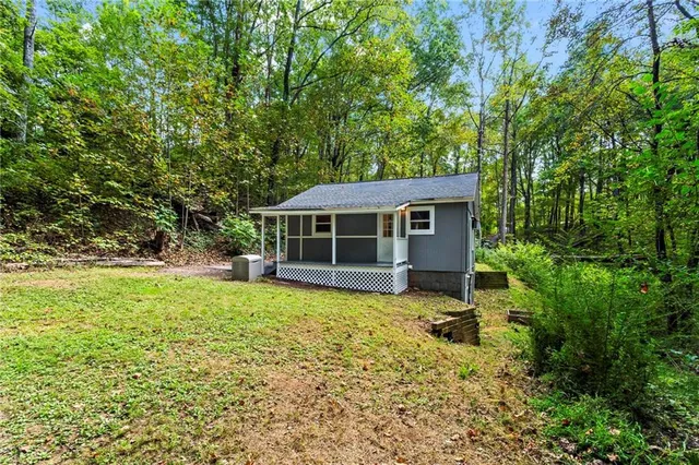 a front view of house with yard and trees in the background
