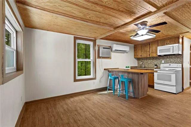 a kitchen with stainless steel appliances granite countertop a stove a sink dishwasher and a refrigerator with wooden floor