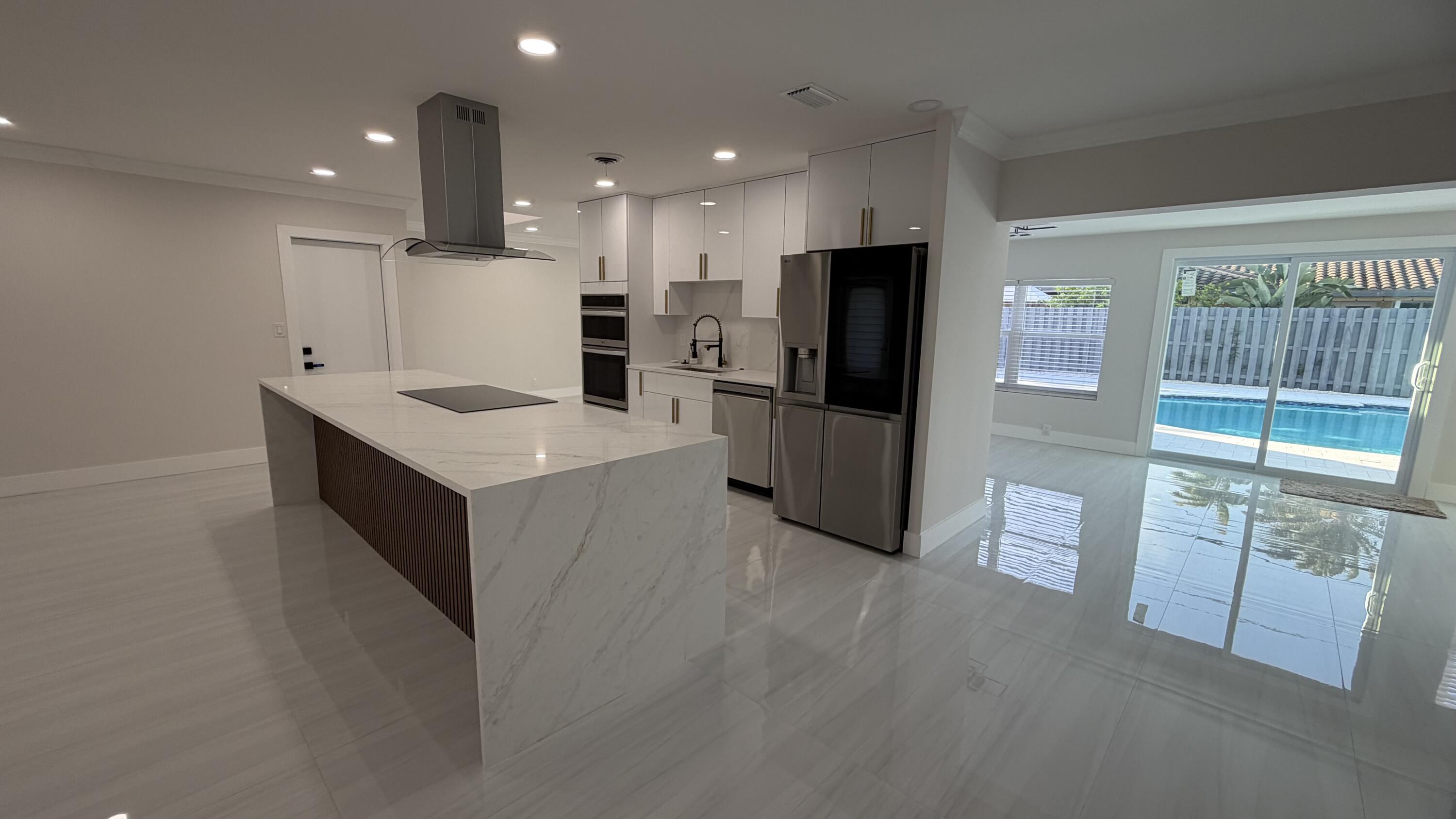 2521 Northeast 45th Street Lighthouse Point, FL 33064 - Photo 9 of 25 a large kitchen with a large counter top appliances and cabinets