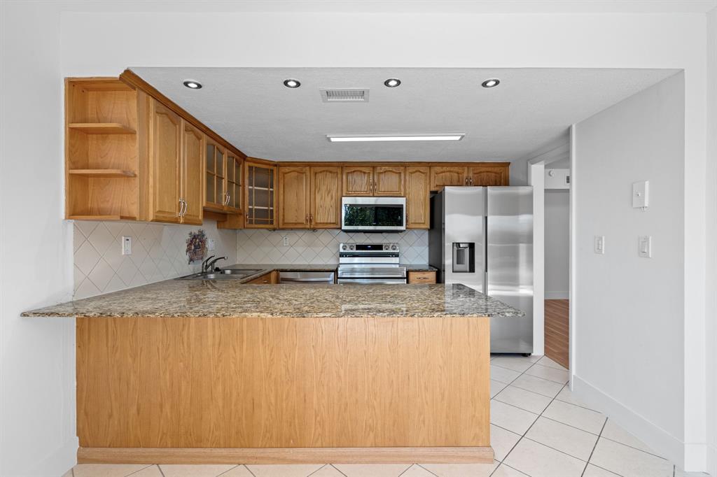5700 Southwest 127th Avenue, Unit 1304 Miami, FL 33183 - Photo 15 of 42 a kitchen with stainless steel appliances granite countertop a sink refrigerator and microwave