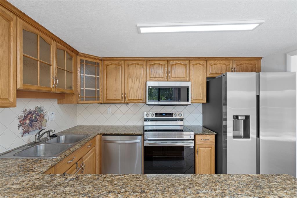 5700 Southwest 127th Avenue, Unit 1304 Miami, FL 33183 - Photo 18 of 42 a kitchen with stainless steel appliances granite countertop a sink stove and refrigerator