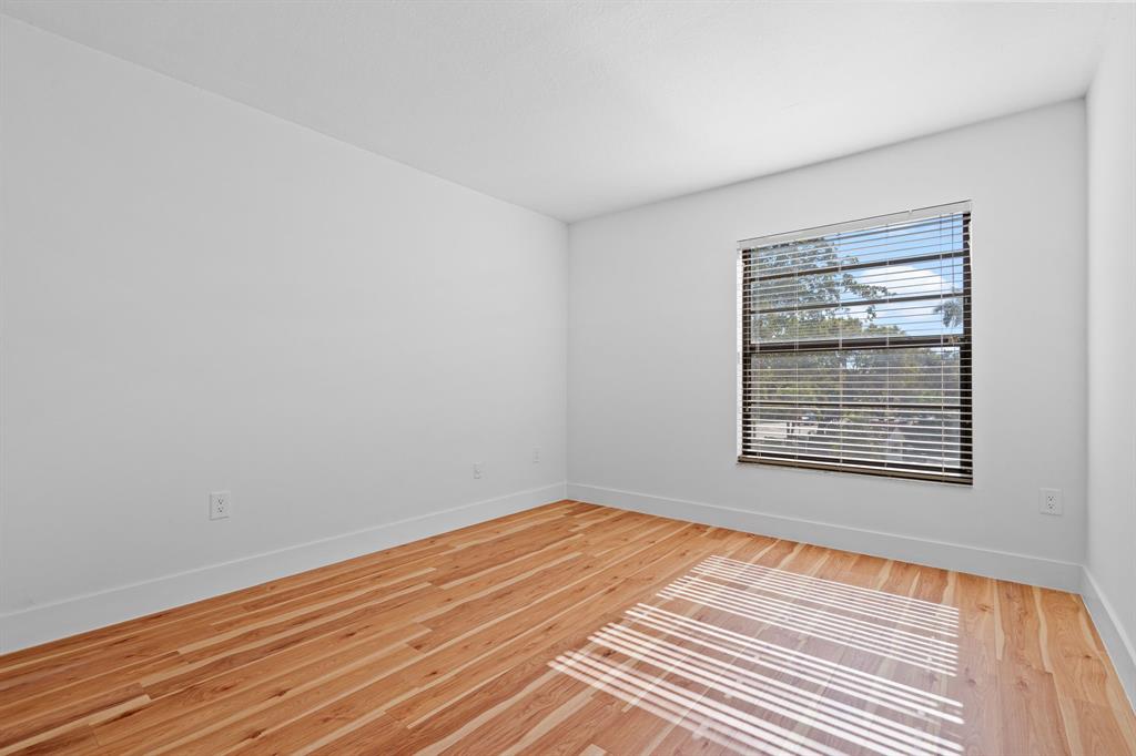 5700 Southwest 127th Avenue, Unit 1304 Miami, FL 33183 - Photo 21 of 42 a view of an empty room with wooden floor and a window
