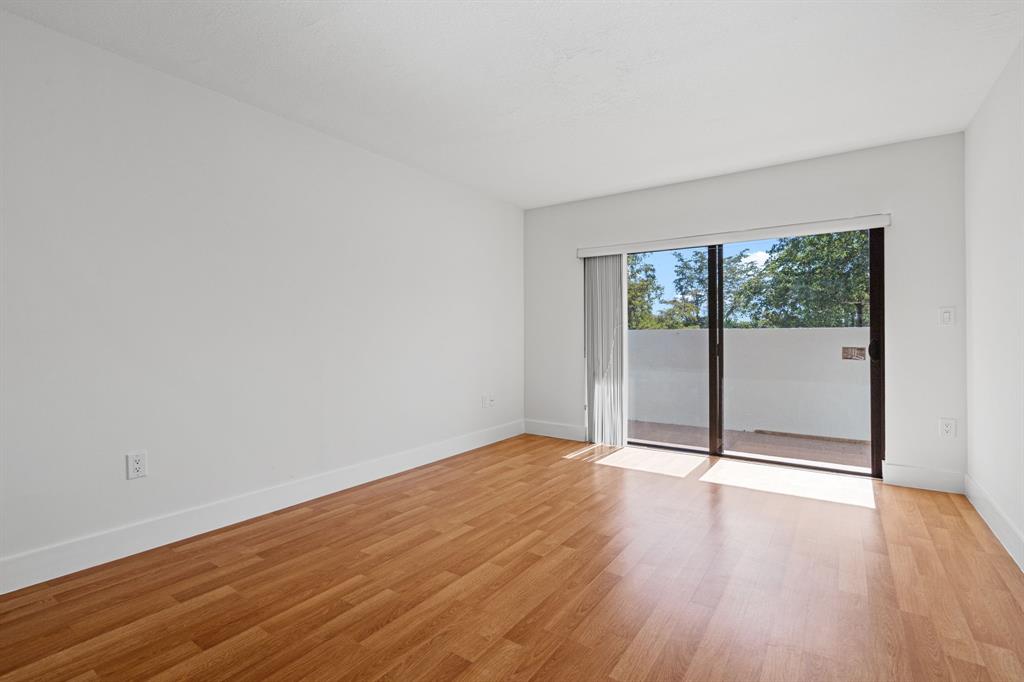 5700 Southwest 127th Avenue, Unit 1304 Miami, FL 33183 - Photo 30 of 42 an empty room with wooden floor and windows