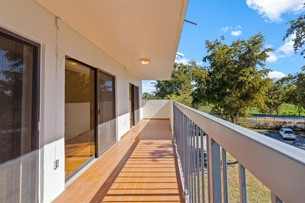 5700 Southwest 127th Avenue, Unit 1304 Miami, FL 33183 - Photo 37 of 42 a view of balcony with wooden floor and a potted plant
