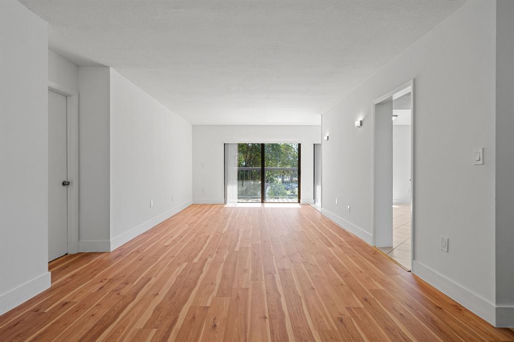 5700 Southwest 127th Avenue, Unit 1304 Miami, FL 33183 - Photo 4 of 42 a view of an empty room with wooden floor and a window